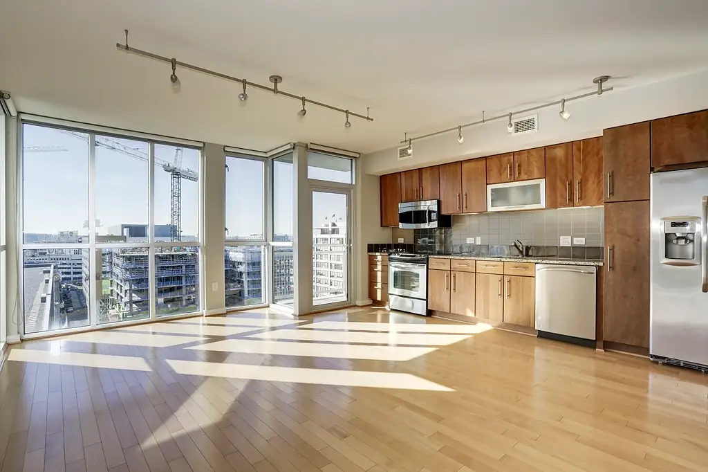 An apartment kitchen with large windows and city views